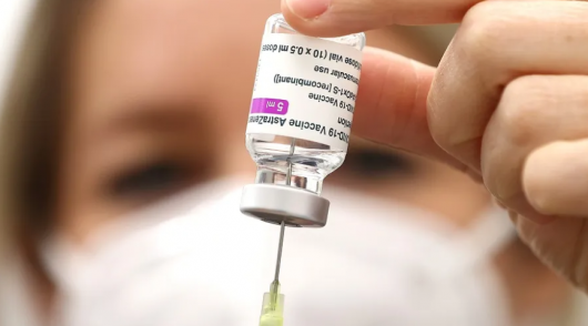 Mão de uma médica insere agulha em um frasco de vacina